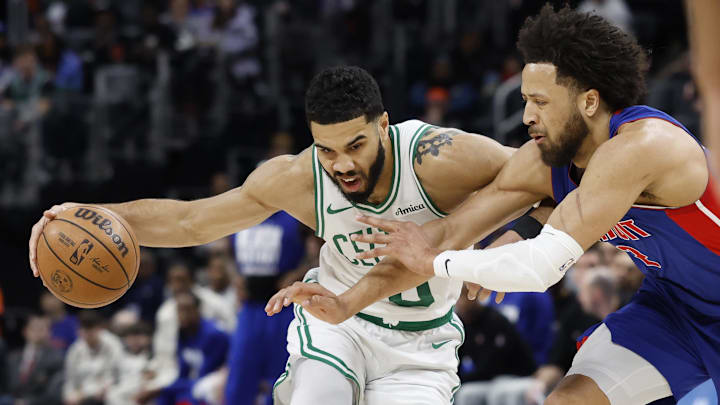 Feb 26, 2025; Detroit, Michigan, USA;  Boston Celtics forward Jayson Tatum (0) dribbles defended by Detroit Pistons guard Cade Cunningham (2) in the first half at Little Caesars Arena. Mandatory Credit: Rick Osentoski-Imagn Images