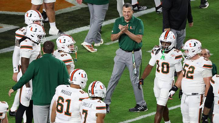 Miami head coach Mario Cristobal speaks to his players during warmups prior to the College Football Playoff National Championship
