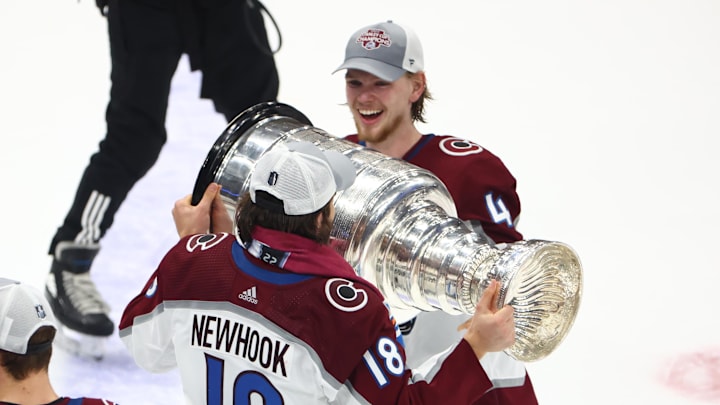 Jun 26, 2022; Tampa, Florida, USA; Colorado Avalanche defenseman Bowen Byram (4) and center Alex Newhook (18) celebrate with the Stanley Cup trophy after defeating the Tampa Bay Lightning during game six of the 2022 Stanley Cup Final at Amalie Arena. Mandatory Credit: Mark J. Rebilas-Imagn Images