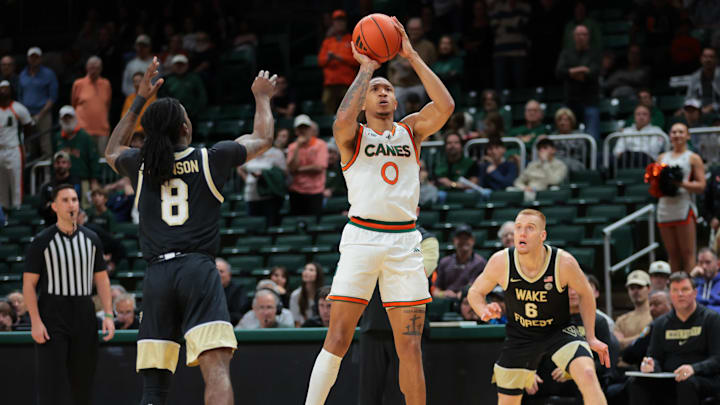 Jan 11, 2025; Coral Gables, Florida, USA; Miami Hurricanes guard Matthew Cleveland (0) shoots the basketball over Wake Forest Demon Deacons guard Ty-Laur Johnson (8) during the first half at Watsco Center. Mandatory Credit: Sam Navarro-Imagn Images