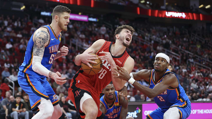 Dec 1, 2024; Houston, Texas, USA; Houston Rockets center Alperen Sengun (28) attempts to secure the ball away from Oklahoma City Thunder center Isaiah Hartenstein (55) and guard Shai Gilgeous-Alexander (2) during the fourth quarter at Toyota Center. Mandatory Credit: Troy Taormina-Imagn Images