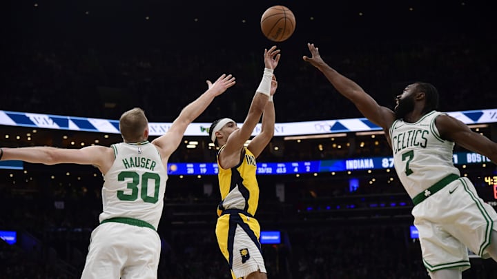 Dec 29, 2024; Boston, Massachusetts, USA; Indiana Pacers guard Andrew Nembhard (2) shoots the ball between Boston Celtics forward Sam Hauser (30) and Boston Celtics guard Jaylen Brown (7) during the second half at TD Garden. Mandatory Credit: Bob DeChiara-Imagn Images
