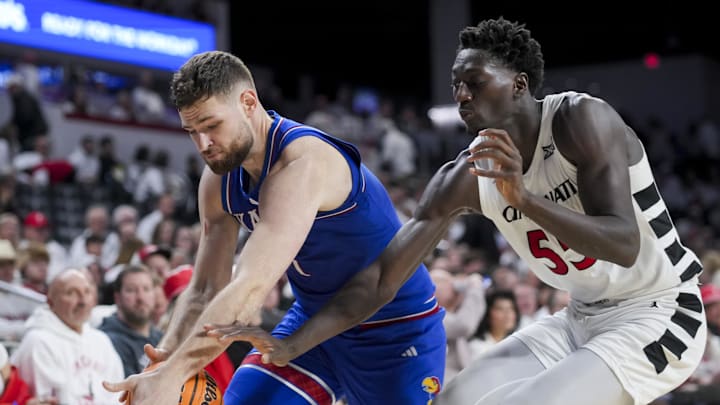 Jan 11, 2025; Cincinnati, Ohio, USA;  Kansas Jayhawks center Hunter Dickinson (1) battles for the loose ball against Cincinnati Bearcats forward Aziz Bandaogo (55) in the second half at Fifth Third Arena. Mandatory Credit: Aaron Doster-Imagn Images