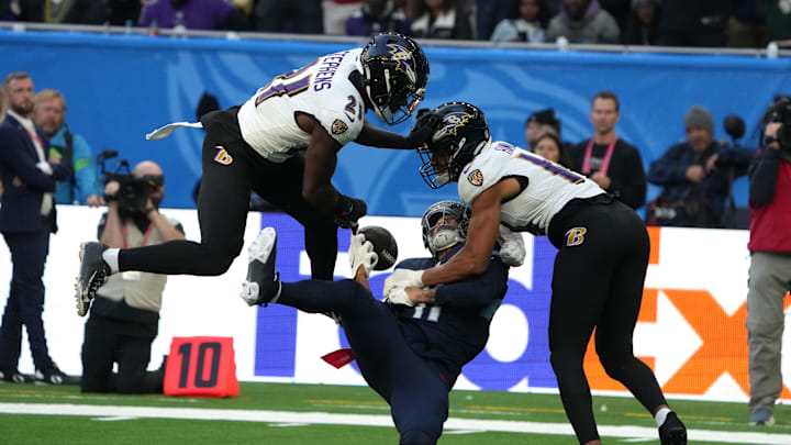 Oct 15, 2023; London, United Kingdom; Tennessee Titans wide receiver Chris Moore (11) attempts to catch the ball against Baltimore Ravens cornerback Brandon Stephens (21) and safety Kyle Hamilton (14) in the second half during an NFL International Series game at Tottenham Hotspur Stadium. Mandatory Credit: Kirby Lee-Imagn Images
