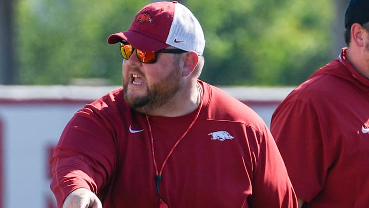 Arkansas Razorbacks offensive line coach Eric Mateos at practice working against the defensive line.