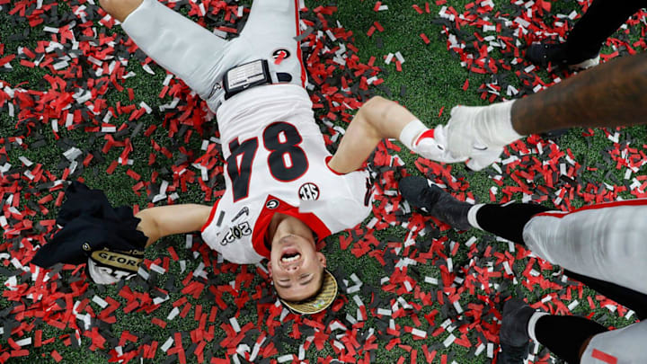 Georgia Bulldogs wide receiver Ladd McConkey (84) lays in confetti after winning the College Football Playoff National Championship on Monday, Jan. 10, 2022, at Lucas Oil Stadium in Indianapolis. The Georgia Bulldogs defeated the Alabama Crimson Tide in the College Football playoff National Championship, 33-18, earning the title for the first time in 41 years. They clinched the win with several touchdowns in the fourth quarter. A 40-yard touchdown by Adonai Mitchell (5), pictured second, gave