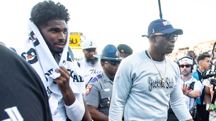 Deion Sanders and his son, quarterback Shedeur Sanders, walk off the field together after a game against the Alabama State Hornets.
