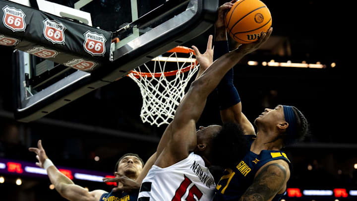 West Virginia Mountaineers guard RaeQuan Battle (21) blocks Cincinnati Bearcats forward John Newman (15)
