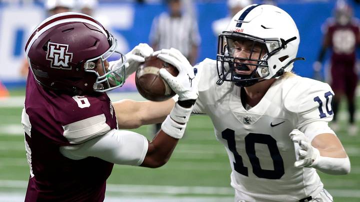 Harper Woods' Dakota Guerrant catches the ball against the defense of Grand Rapids South Christian's Tanner Raak during the MHSAA Division 4 high school football state championship game at Ford Field in Detroit on Saturday, November 25, 2023.