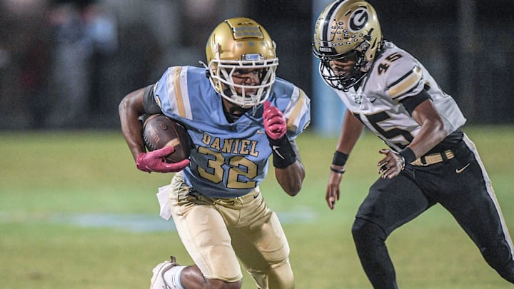 D.W. Daniel High School freshman Trey Wimbley (32) runs near Greer High senior Quamaine Dodd (45) during the first quarter at DW Daniel High School in Central, S.C. Friday, November 1, 2024.
