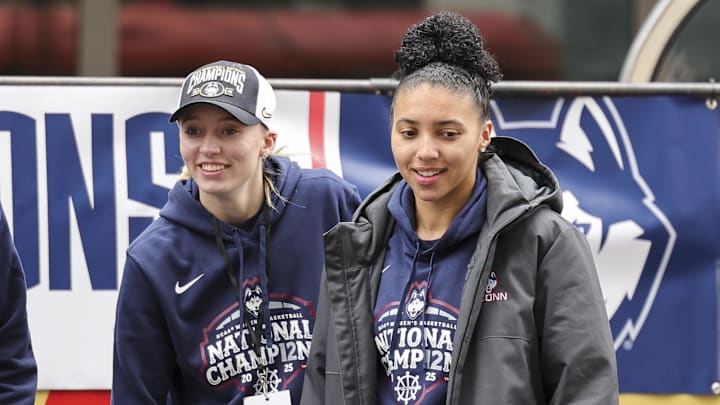 Apr 13, 2025; Hartford, CT, USA;  UConn student-athlete Paige Bueckers and UConn student-athlete Azzi Fudd walk onto the stage during the Final Four Champions victory parade and rally outside of the XL Center in Hartford, CT. Mandatory Credit: Scott Rausenberger-Imagn Images