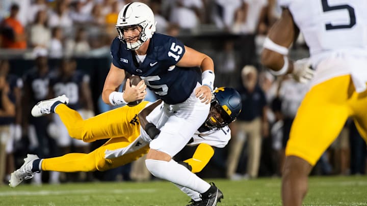 Penn State quarterback Drew Allar slips a sack attempt from West Virginia linebacker Trey Lathan