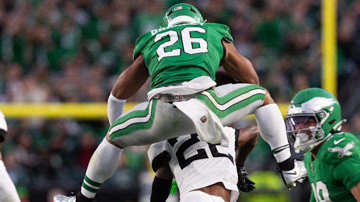 Philadelphia Eagles running back Saquon Barkley hurdles over a defender during a game.