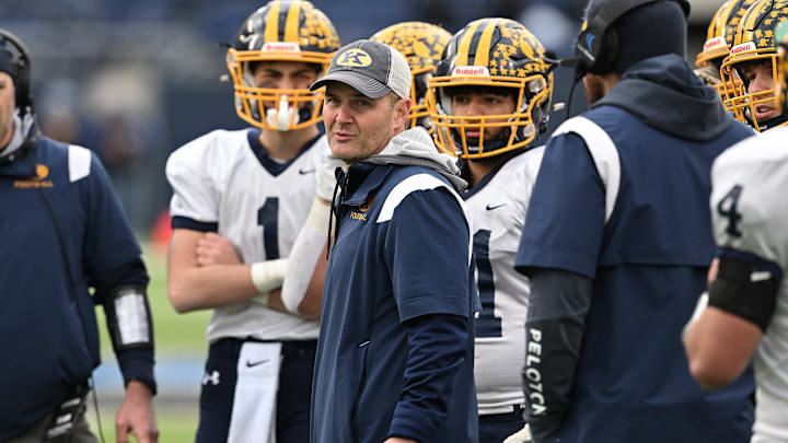 Kirtland football coach Tiger LaVerde meets with his team during the 2023 state championship game.