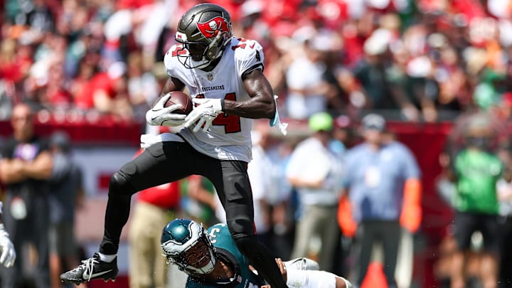 Sep 29, 2024; Tampa, Florida, USA; Tampa Bay Buccaneers wide receiver Chris Godwin (14) stretches past Philadelphia Eagles linebacker Nolan Smith Jr. (3) for extra yards in the second quarter at Raymond James Stadium. Mandatory Credit: Nathan Ray Seebeck-Imagn Images