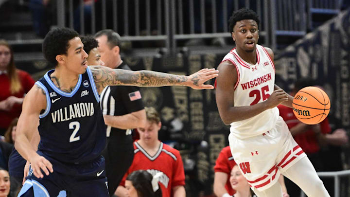 Dec 19, 2025; Milwaukee, Wisconsin, USA; Wisconsin Badgers guard John Blackwell (25) drives for the basket against Villanova Wildcats guard Bryce Lindsay (2) second half at the Fiserv Forum. Mandatory Credit: Benny Sieu-Imagn Images