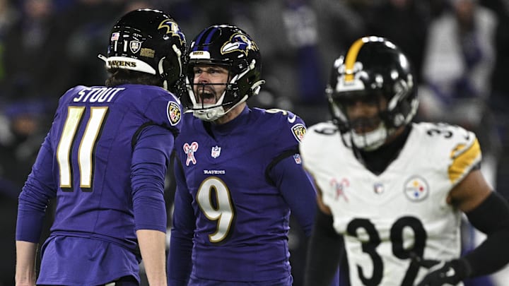 Dec 21, 2024; Baltimore, Maryland, USA;  Baltimore Ravens place kicker Justin Tucker (9) celebrates with punter Jordan Stout (11) after kicking a field goal as Pittsburgh Steelers safety Minkah Fitzpatrick (39) runs by after kicking at M&T Bank Stadium. Mandatory Credit: Tommy Gilligan-Imagn Images