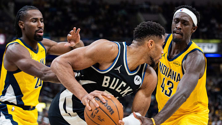 Nov 3, 2025; Indianapolis, Indiana, USA; Milwaukee Bucks forward Giannis Antetokounmpo (34) holds the ball while Indiana Pacers forward Pascal Siakam (43) and guard/forward Aaron Nesmith (23) defend in the second half at Gainbridge Fieldhouse. Mandatory Credit: Trevor Ruszkowski-Imagn Images