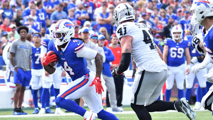 Sep 17, 2023; Orchard Park, New York, USA; Buffalo Bills running back James Cook (4) runs past Las Vegas Raiders linebacker Robert Spillane (41) in the third quarter at Highmark Stadium. Mandatory Credit: Mark Konezny-Imagn Images