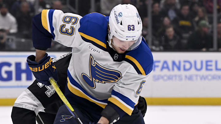 Mar 5, 2025; Los Angeles, California, USA;  St. Louis Blues left wing Jake Neighbours (63) controls the puck against Los Angeles Kings defenseman Mikey Anderson (44) during the third period at Crypto.com Arena. Mandatory Credit: Alex Gallardo-Imagn Images