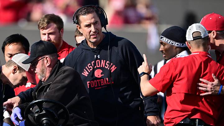 Nov 15, 2025; Bloomington, Indiana, USA; Wisconsin Badgers head coach Luke Fickell stands in the crowd surrounding an injured Wisconsin Badgers running back Gideon Ituka during the second half against the against the Indiana Hoosiers at Memorial Stadium. Mandatory Credit: Marc Lebryk-Imagn Images