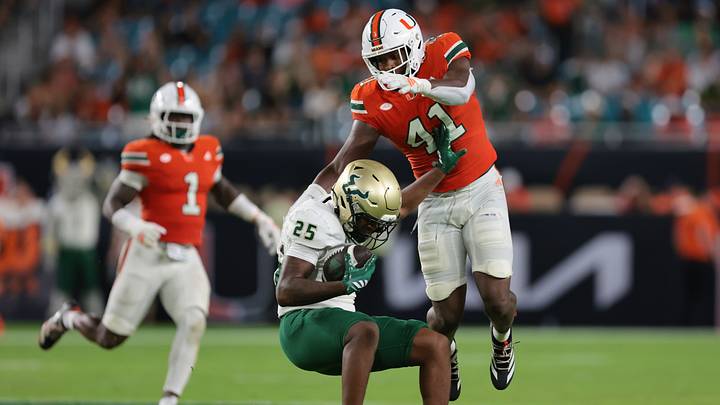 Sep 13, 2025; Miami Gardens, Florida, USA; South Florida Bulls running back Nykahi Davenport (25) is tackled by Miami Hurricanes linebacker Chase Smith (41) during the third quarter at Hard Rock Stadium. Mandatory Credit: Sam Navarro-Imagn Images Sep 13, 2025; Miami Gardens, Florida, USA; South Florida Bulls running back Nykahi Davenport (25) is tackled by Miami Hurricanes linebacker Chase Smith (41) during the third quarter at Hard Rock Stadium. Mandatory Credit: Sam Navarro-Imagn Images