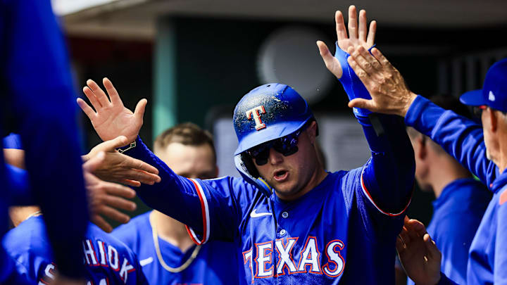 Apr 2, 2025; Cincinnati, Ohio, USA; Texas Rangers designated hitter Joc Pederson (4) high fives teammates after scoring on a RBI double hit by shortstop Josh Smith (not pictured) in the fourth inning against the Cincinnati Reds at Great American Ball Park. 