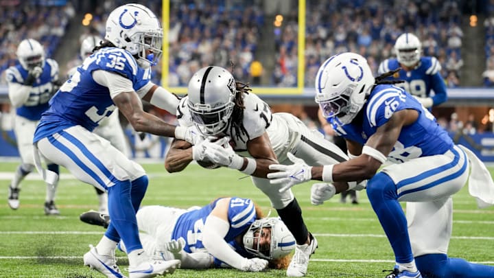 Las Vegas Raiders wide receiver Davante Adams (17) comes up short as he dives toward the end zone between Indianapolis Colts cornerback Chris Lammons (35) and Indianapolis Colts safety Ronnie Harrison Jr. (48) on Sunday, Dec. 31, 2023, during a game against the Las Vegas Raiders at Lucas Oil Stadium in Indianapolis.