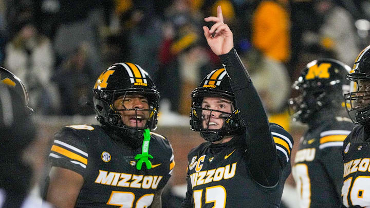 Nov 30, 2024; Columbia, Missouri, USA; Missouri Tigers quarterback Brady Cook (12) celebrates with running back Jamal Roberts (20) after scoring the game-winning touchdown against the Arkansas Razorbacks during the first half at Faurot Field at Memorial Stadium. Mandatory Credit: Denny Medley-Imagn Images