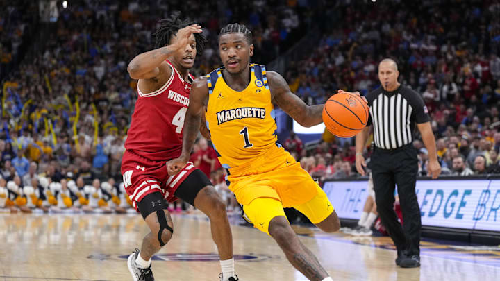 Dec 7, 2024; Milwaukee, Wisconsin, USA;  Marquette Golden Eagles guard Kam Jones (1) drives for the basket in front of Wisconsin Badgers guard Kamari McGee (4) during the second half at Fiserv Forum. Mandatory Credit: Jeff Hanisch-Imagn Images