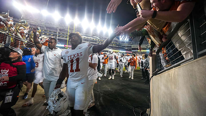 Texas Longhorns edge rusher Colin Simmons (11) and Texas fans celebrate the 17-7 win over Texas A&M in the Lone Star Showdown at Kyle Field on Saturday, Nov. 30, 2024 in College Station, Texas. Texas Longhorns edge rusher Colin Simmons (11) and Texas fans celebrate the 17-7 win over Texas A&M in the Lone Star Showdown at Kyle Field on Saturday, Nov. 30, 2024 in College Station, Texas.