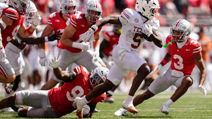 Texas Longhorns running back Quintrevion Wisner (5) runs past Ohio State Buckeyes defensive end Eddrick Houston (96) during the second half of the NCAA football game at Ohio Stadium on Aug. 30, 2025. Ohio State won 14-7.