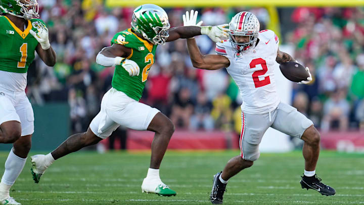 Ohio State Buckeyes wide receiver Emeka Egbuka (2) runs [ast Oregon Ducks linebacker Jeffrey Bassa (2) and defensive end Jordan Burch (1) during the first half of the College Football Playoff quarterfinal at the Rose Bowl in Pasadena, Calif. on Jan. 1, 2025. Ohio State Buckeyes wide receiver Emeka Egbuka (2) runs [ast Oregon Ducks linebacker Jeffrey Bassa (2) and defensive end Jordan Burch (1) during the first half of the College Football Playoff quarterfinal at the Rose Bowl in Pasadena, Calif. on Jan. 1, 2025.
