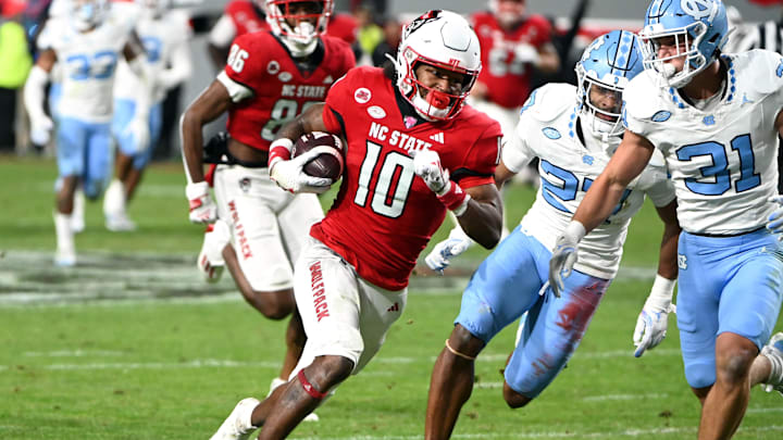 Nov 25, 2023; Raleigh, North Carolina, USA; North Carolina State Wolfpack receiver KC Concepcion (10) runs after a catch against North Carolina Tar Heels defensive back Will Hardy (31) during the first half at Carter-Finley Stadium. Mandatory Credit: Rob Kinnan-Imagn Images