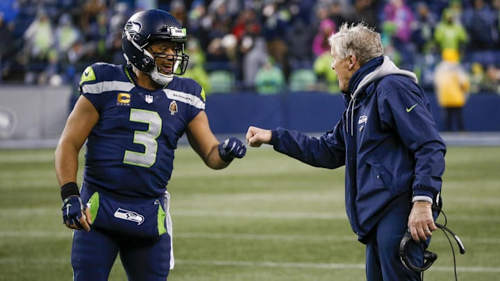 Jan 2, 2022; Seattle, Washington, USA; Seattle Seahawks quarterback Russell Wilson (3) bumps fists with head coach Pete Carroll during the fourth quarter two-minute warning against the Detroit Lions at Lumen Field. Mandatory Credit: Joe Nicholson-Imagn Images