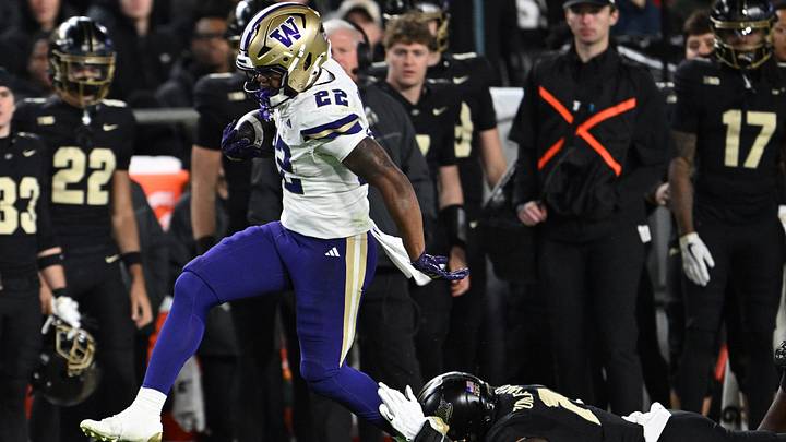 UW running back Trey Cooley (22) steps out of a tackle by Purdue defensive lineman Keyshawn Burgos (11) on Friday night. UW running back Trey Cooley (22) steps out of a tackle by Purdue defensive lineman Keyshawn Burgos (11) on Friday night.