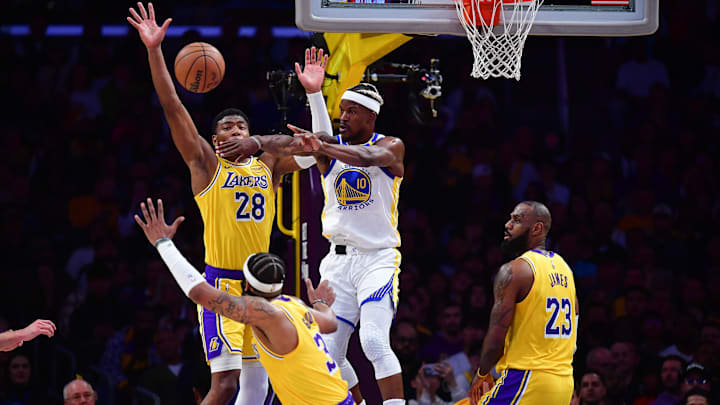 Apr 3, 2025; Los Angeles, California, USA; Golden State Warriors forward Jimmy Butler III (10) passes the ball against Los Angeles Lakers forward Rui Hachimura (28) guard Jordan Goodwin (30) and forward LeBron James (23) during the first half at Crypto.com Arena. Mandatory Credit: Gary A. Vasquez-Imagn Images