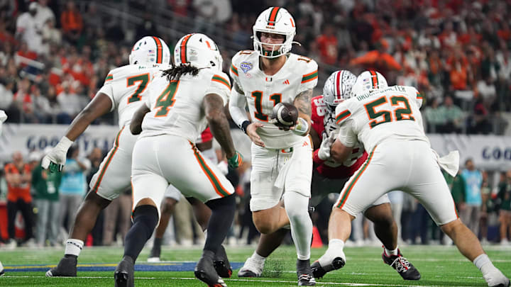 Dec 31, 2025; Arlington, TX, USA; Miami Hurricanes quarterback Carson Beck (11) hands off to running back Mark Fletcher Jr. (4) in the second quarter against the Ohio State Buckeyes during the 2025 Cotton Bowl and quarterfinal game of the College Football Playoff at AT&T Stadium. Mandatory Credit: Raymond Carlin III-Imagn Images