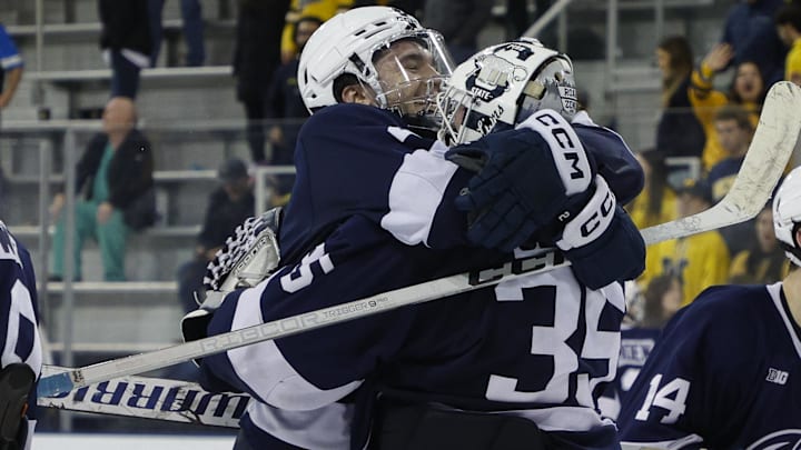 Penn State men's hockey defenseman Casey Aman celebrates with former Penn State goaltender Arsenii Sergeev