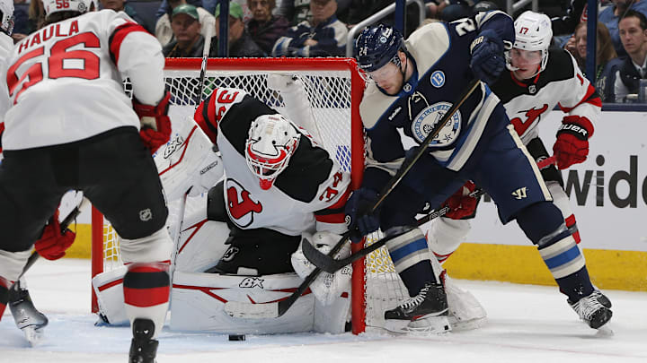 Mar 17, 2025; Columbus, Ohio, USA; New Jersey Devils goalie Jake Allen (34) stops the wrap around attempt of Columbus Blue Jackets center Mathieu Olivier (24) during the third period at Nationwide Arena. Mandatory Credit: Russell LaBounty-Imagn Images