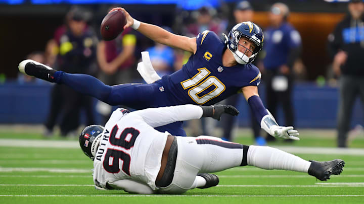 Los Angeles Chargers quarterback Justin Herbert (10) is sacked by Houston Texans defensive end Denico Autry (96) during the first half at SoFi Stadium.