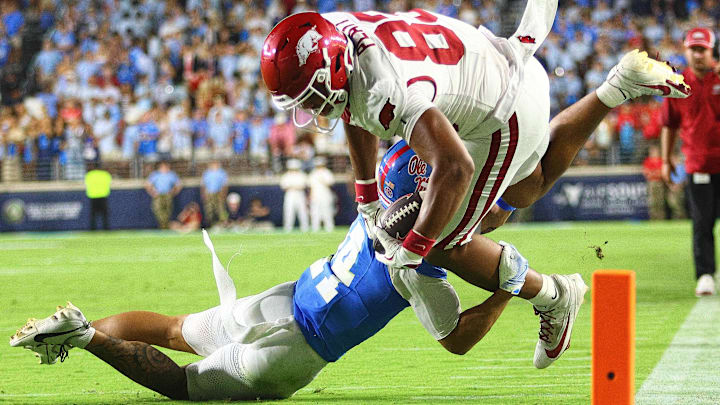 Arkansas tight end Jaden Platt (83) tries to hold onto the ball as Ole Miss defensive back Kapena Gushiken (14) makes a diving tackle during the fourth quarter at Vaught-Hemingway Stadium.