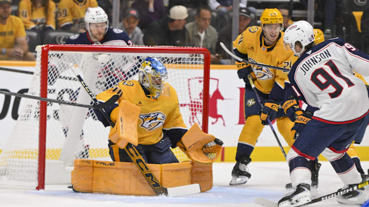 Oct 9, 2025; Nashville, Tennessee, USA; Nashville Predators goaltender Juuse Saros (74) blocks the shot of Columbus Blue Jackets center Kent Johnson (91) during the first period at Bridgestone Arena. Mandatory Credit: Steve Roberts-Imagn Images