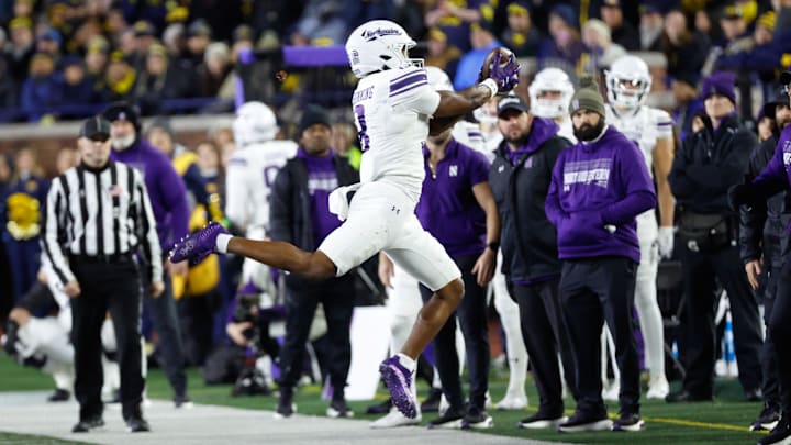 Nov 23, 2024; Ann Arbor, Michigan, USA;  Northwestern Wildcats wide receiver A.J. Henning (8) tries to make a catch against the Michigan Wolverines at Michigan Stadium. Mandatory Credit: Rick Osentoski-Imagn Images