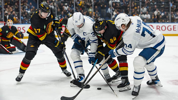Jan 31, 2026; Vancouver, British Columbia, CAN; Vancouver Canucks defenseman Tyler Myers (57) and forward David Kampf (64) battle with Toronto Maple Leafs forward Auston Matthews (34) and forward Bobby McMann (74) in the third period at Rogers Arena. Mandatory Credit: Bob Frid-Imagn Images