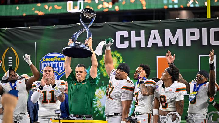 Dec 31, 2025; Arlington, TX, USA; Miami Hurricanes head coach Mario Cristobal hoists the trophy as he celebrates with his team after the 2025 Cotton Bowl and quarterfinal game of the College Football Playoff at AT&T Stadium. Mandatory Credit: Jerome Miron-Imagn Images