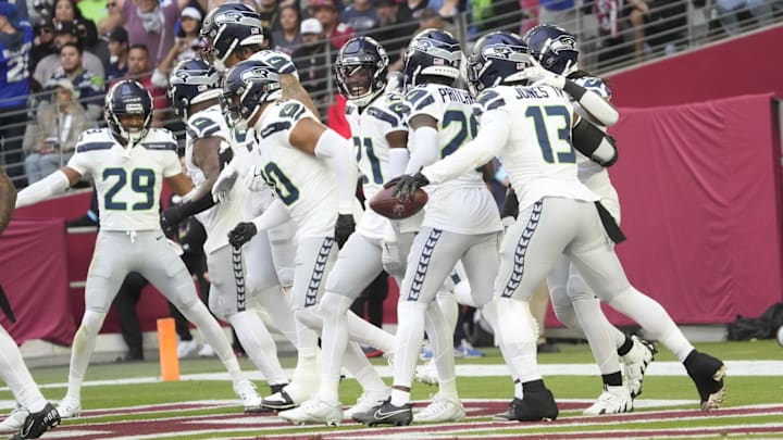 Seattle Seahawks linebacker Ernest Jones IV (13) is congratulated after an interception against the Arizona Cardinals during the first quarter at State Farm Stadium in Glendale on Dec. 8, 2024.