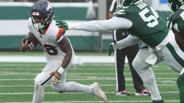 East Rutherford, NJ -- September 29 -- Tyler Badie of Denver runs from Javon Kinlaw of the Jets in the first half as the Denver Broncos edged the New York Jets 10-9 at MetLife Stadium.