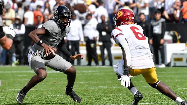 Sep 30, 2023; Boulder, Colorado, USA; Colorado Buffaloes quarterback Shedeur Sanders (2) attempts to scramble from USC Trojans defensive lineman Anthony Lucas (6) during the fourth quarter at Folsom Field. Mandatory Credit: John Leyba-Imagn Images