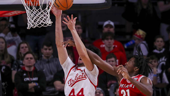 Dec 14, 2022; Cincinnati, Ohio, USA; Cincinnati Bearcats forward Sage Tolentino (44) shoots against Miami Redhawks forward Jaquel Morris (21) in the second half at Fifth Third Arena. Mandatory Credit: Katie Stratman-Imagn Images Dec 14, 2022; Cincinnati, Ohio, USA; Cincinnati Bearcats forward Sage Tolentino (44) shoots against Miami Redhawks forward Jaquel Morris (21) in the second half at Fifth Third Arena. Mandatory Credit: Katie Stratman-Imagn Images